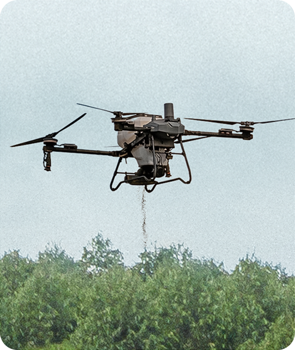 Drone spraying pesticide over a green crop field under a gray sky